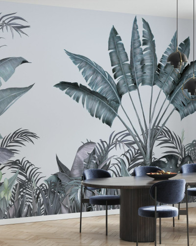 Tapet tropical cu frunze de palmier în nuanțe de albastru și verde, decorat într-o sufragerie cu o masă și scaune din lemn și o canapea albă.