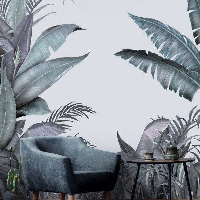 Tapet tropical cu frunze de palmier în nuanțe de albastru și verde, decorat într-o sufragerie cu o masă și scaune din lemn și o canapea albă.