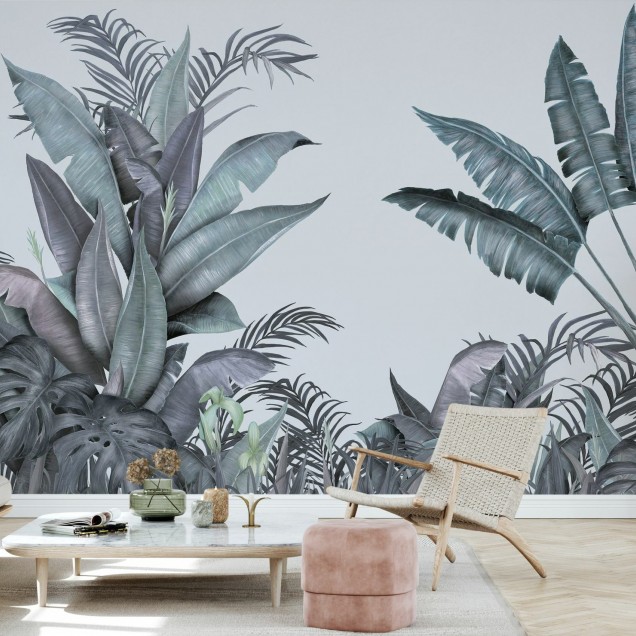 Tapet tropical cu frunze de palmier în nuanțe de albastru și verde, decorat într-o sufragerie cu o masă și scaune din lemn și o canapea albă.