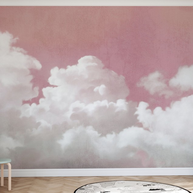 Wallpaper cu nori pufoși albi pe un fundal roz pal, în interiorul unei camere de copii cu pat alb, lampă albă, geam cu perdea albă, un scaun din ratan și un covor verde.