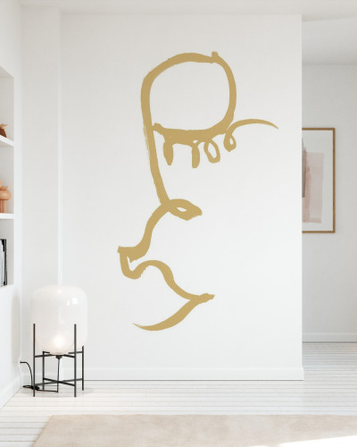 Half Face, Gold tapet minimalist cu o jumătate de față pictată în aur pe un perete alb într-un interior modern.