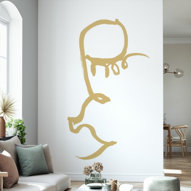 Half Face, Gold tapet minimalist cu o jumătate de față pictată în aur pe un perete alb într-un interior modern.