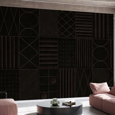 Tapet abstract modern cu forme geometrice și tonuri de gri închis, aplicat pe un perete într-un living modern, cu o canapea gri și o masă de cafea neagră.