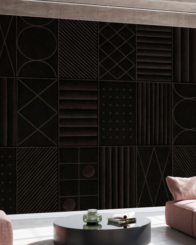 Tapet abstract modern cu forme geometrice și tonuri de gri închis, aplicat pe un perete într-un living modern, cu o canapea gri și o masă de cafea neagră.