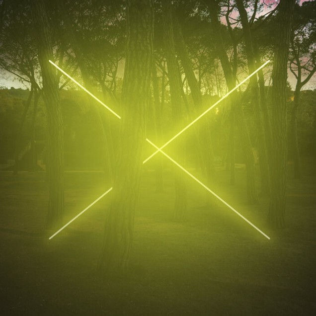 Tapet Yellow Neon Cross Light cu o cruce strălucitoare de neon pe fundalul unui pădure verde.