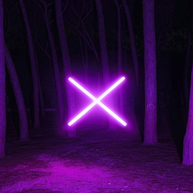 Imagine cu un wallpaper cu lumină violet fluorescentă într-o pădure întunecată. Wallpaper-ul este aplicat pe un perete din livingul unei case moderne. În imagine se poate vedea o canapea gri, o măsuță de cafea și un geam mare cu vedere la oraș.