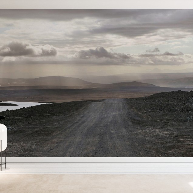 A wallpaper with a scenic view of a winding road in a desolate landscape under a cloudy sky.