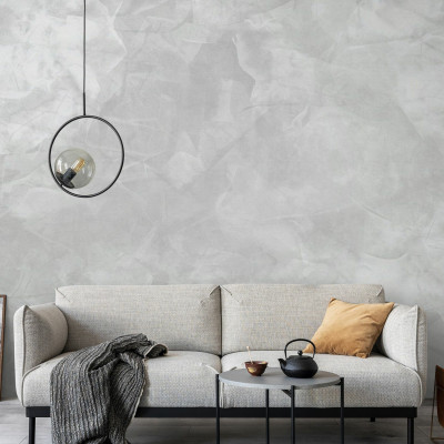 Tapet Mineral Matter gri deschis, cu aspect de beton, in living, cu canapea, masa, si accesorii decorative
