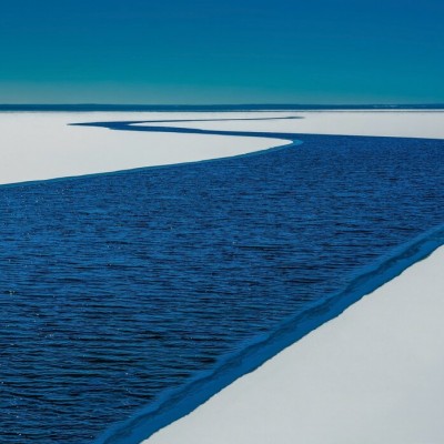 Tapet foto cu un râu albastru care se varsă intr-un lac albastru, pe un fundal alb.