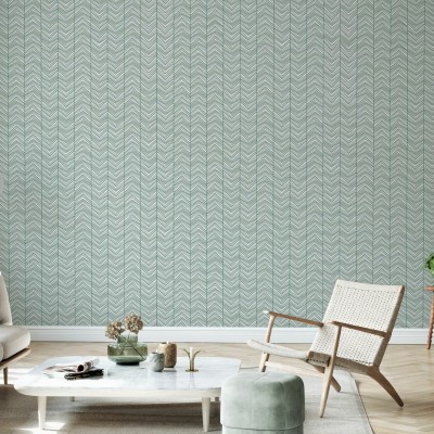 Tapet Herringbone Green în living, cu canapea gri și scaun din răchită.