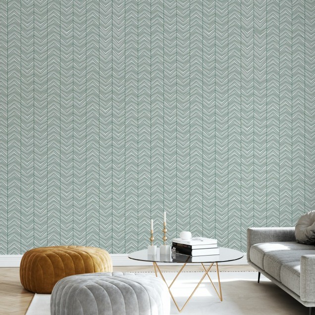 Tapet Herringbone Green în living, cu canapea gri și scaun din răchită.