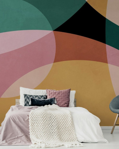 Tapet geometric abstract cu culori vibrante de verde, roz, portocaliu și galben, aplicat pe un perete din dormitor