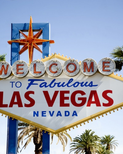 Imagine cu un tapet cu semnul “Welcome to Fabulous Las Vegas” pe un perete dintr-un living.