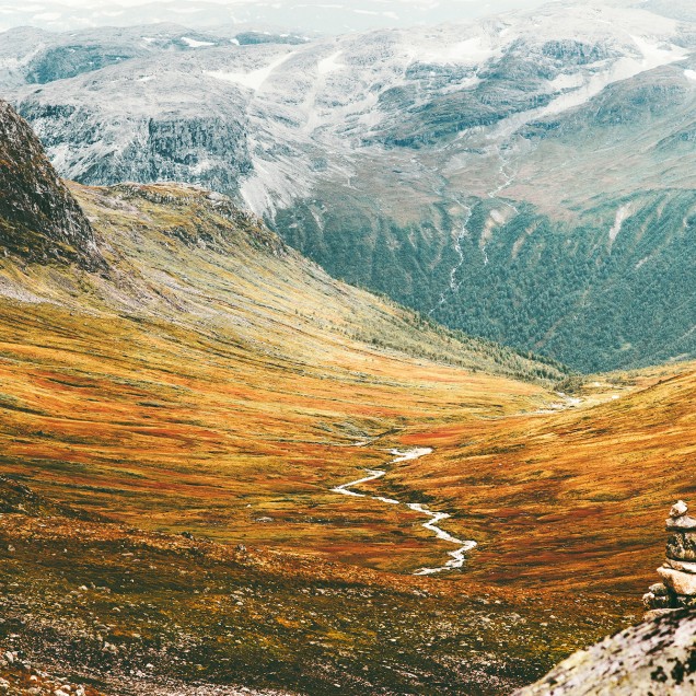 Tapet cu imagine a unui lanț muntos cu culori calde și tonuri de verde