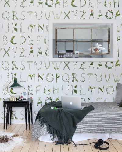 Tapet cu design floral si alfabet, in camera cu pat si o canapea.