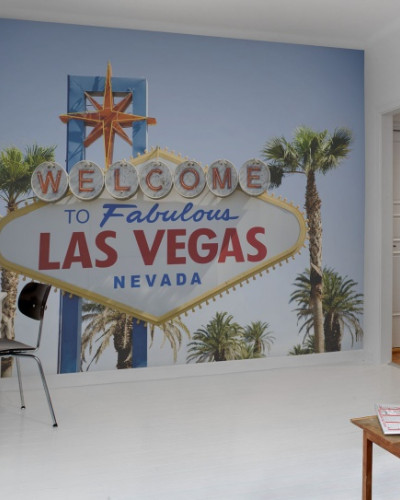 Imagine cu un tapet cu semnul “Welcome to Fabulous Las Vegas” pe un perete dintr-un living.