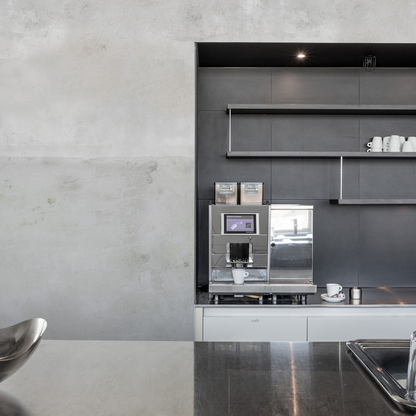 Tapet Urban Horizon Sand, cu aspect de beton texturat, aplicat pe un perete din dormitor