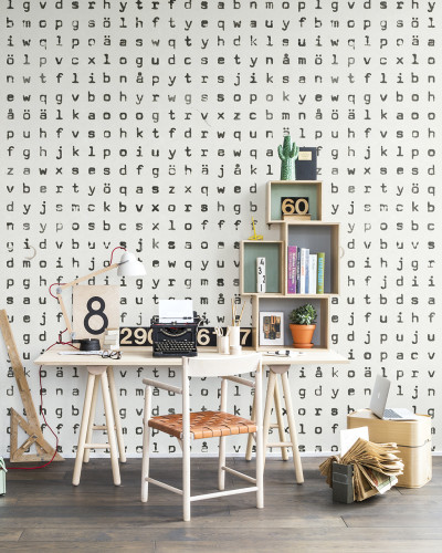 Tapet cu design repetitiv, ce prezintă o repetiție de litere. Tapetul este aplicat într-un interior modern, cu un birou, o canapea și plante.