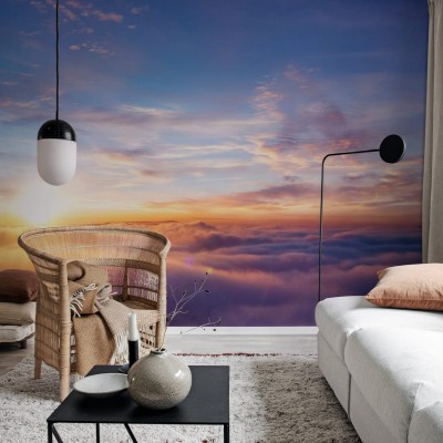 Un tapet cu un apus de soare vibrant, reflectat în nori, într-un living modern.