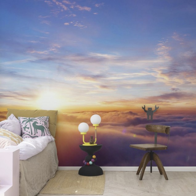 Un tapet cu un apus de soare vibrant, reflectat în nori, într-un living modern.
