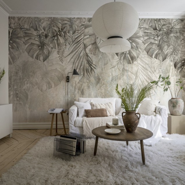 Tapet cu frunze de Monstera într-un interior modern, decorat cu o masă din lemn și scaune negre.