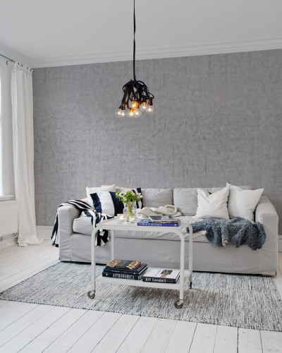 Tapet cu aspect de beton gri deschis, in livingul unei case modern decorate in stil minimalist.