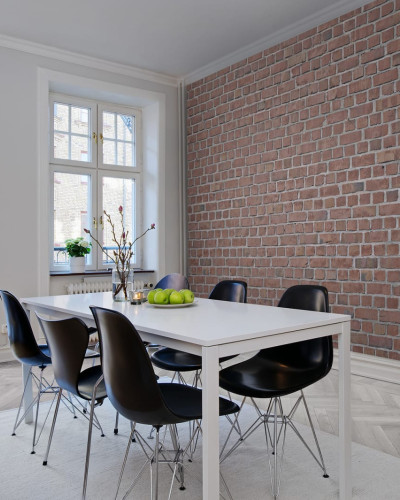 Tapetă cu aspect de cărămidă roșie, în stil industrial, în interiorul unei sufragerii.