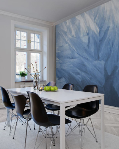 Tapet cu design abstract, Feathers, in nuante de albastru, aplicat intr-o camera de dining cu o masa alba si scaune negre.