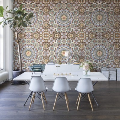 Tapet geometric cu model islamic, în culori vibrante, aplicat pe un perete din interiorul unei case.