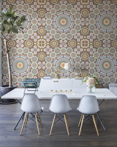 Tapet geometric cu model islamic, în culori vibrante, aplicat pe un perete din interiorul unei case.