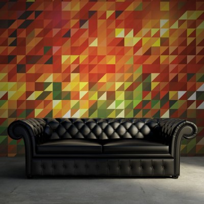 Tapet geometric abstract Slanted cu culori calde,  pe un perete din spatele unei canapele negre
