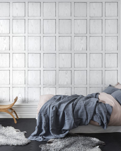 Tapet 3D cu panouri albe în design minimalist, prezentat într-un dormitor cu patul aranjat cu lenjerie de pat gri și roz.