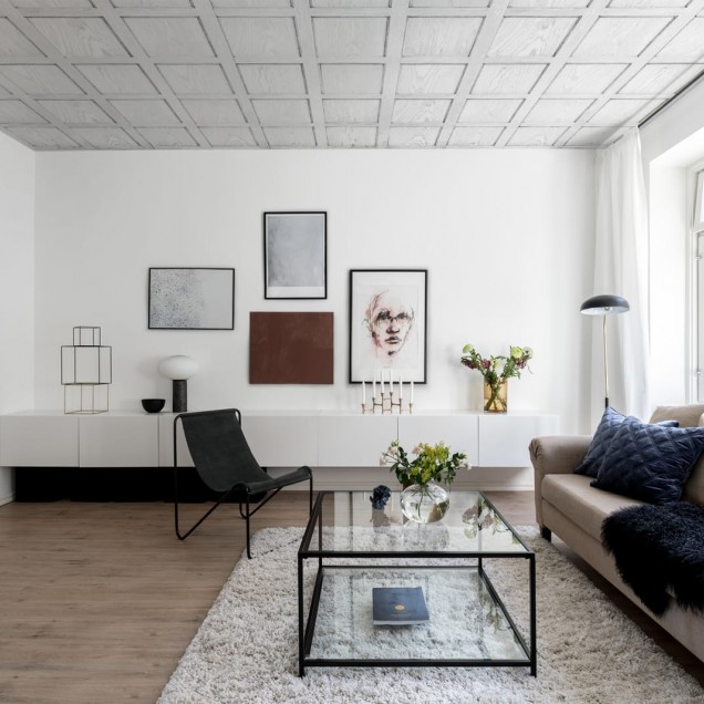 Tapet 3D cu panouri albe în design minimalist, prezentat într-un dormitor cu patul aranjat cu lenjerie de pat gri și roz.
