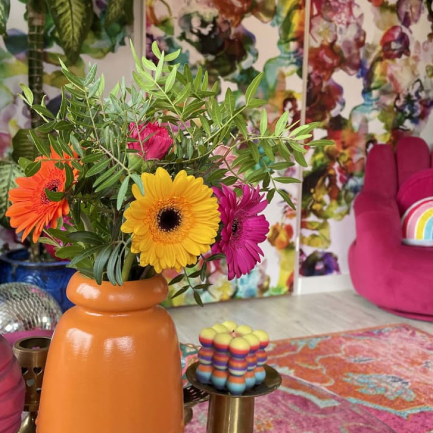 Tapet floral cu flori mari în culori verde și albastru deschis pe un fundal alb, în interiorul unui dormitor modern