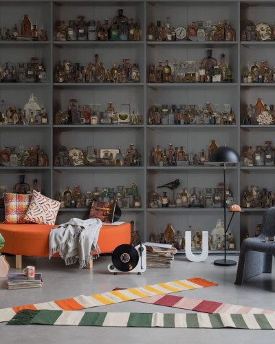 Tapet 3D Cabinet of Curios, Night, cu un design enigmatic ce ilustreaza rafturi pline de sticle cu lichide de diverse culori, perfecte pentru a crea o atmosfera unica in living, dormitor sau birou.