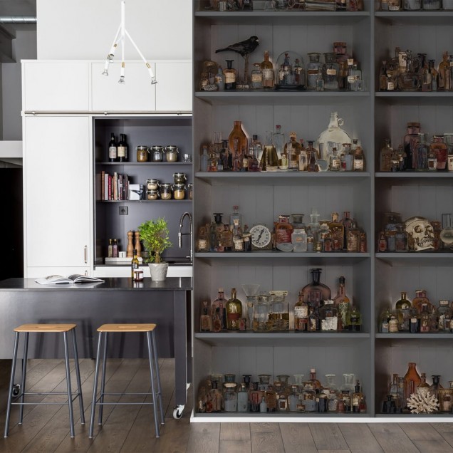 Tapet 3D Cabinet of Curios, Night, cu un design enigmatic ce ilustreaza rafturi pline de sticle cu lichide de diverse culori, perfecte pentru a crea o atmosfera unica in living, dormitor sau birou.