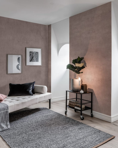 Tapet Solid Blush - O nuanță delicată de roz, perfectă pentru living, dormitor sau baie. Imaginea prezintă o cameră cu canapea, covor, plante și alte decorațiuni, toate armonizate cu culoarea tapetului.