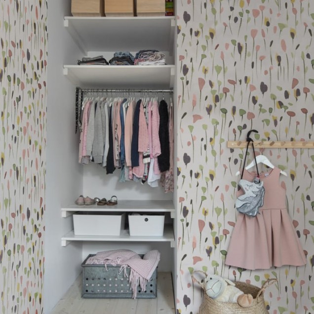 Tapet cu model floral abstract, cu aspect pictat, pe un perete dintr-o cameră cu o masă și scaune.