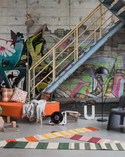 Tapet foto cu design urban - Stairway Graffiti, care prezintă un perete cu grafitti colorat, o scară metalică și beton brut.