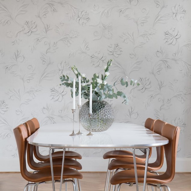 Imagine cu un wallpaper 3D cu un model subtil de flori, în stil minimalist și elegant. Este folosit într-un dormitor amenajat cu mobilier modern.