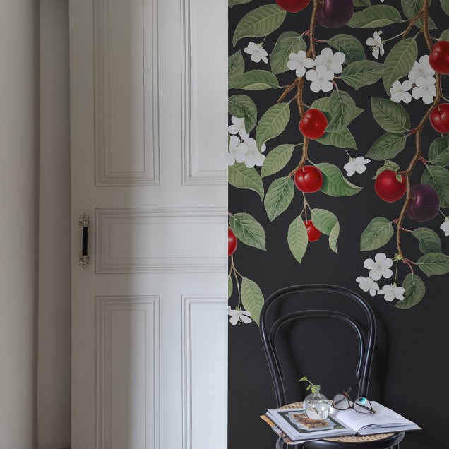 Wallpaper Mirabelle, Midnight cu ramuri pline de frunze verzi, flori albe delicate și prune roșii suculente, toate pe un fundal negru elegant.