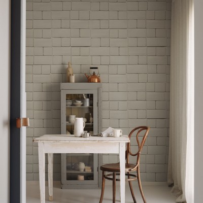 Tapet cu aspect de cărămidă gri, Flight of Tiles, Clay, într-o încăpere cu o masă, un scaun și un dulap cu uși de sticlă.