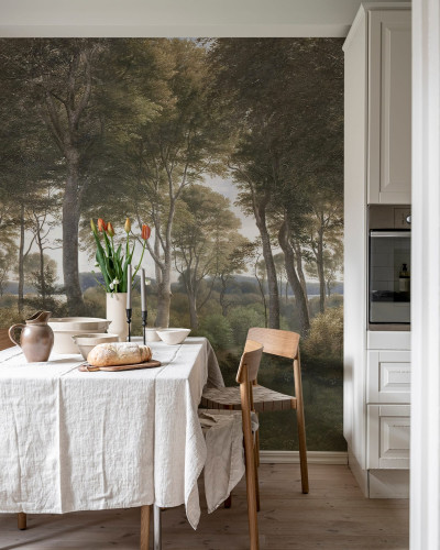 Tapet cu pădure daneză. Imaginea prezintă un living cu un tapet cu pădure daneză pe un perete. În colțul camerei se află o masă de dining cu scaune din lemn și o față de masă albă.