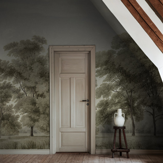 Un tapet cu design minimalist și elegant ce ilustrează o pădure liniștită, în culori delicate. Tapetul este aplicat pe un perete din dormitor, deasupra unui pat cu lenjerie albă.