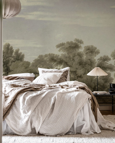 Un tapet cu design minimalist și elegant ce ilustrează o pădure liniștită, în culori delicate. Tapetul este aplicat pe un perete din dormitor, deasupra unui pat cu lenjerie albă.