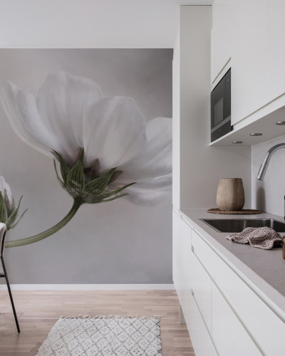 Fototapet cu floare albă delicată pe un fundal gri deschis, în decorul unei bucătării moderne.
