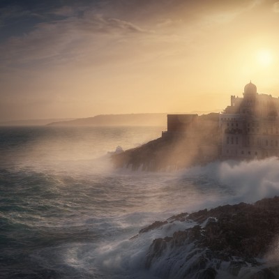 Tapet cu imagine a unei linii de coastă dramatice, cu ape tulburi, un oraș fermecător în depărtare și razele soarelui strălucind prin nori.
