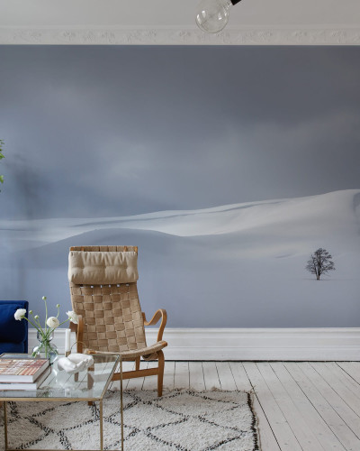 Tapet Snowy Hills, cu un design minimalist, cu dealuri acoperite de zăpadă, un cer senin și un singur copac solitar, care creează o atmosferă relaxantă și introspectivă.