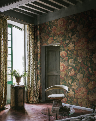 Tapet floral vintage în nuanțe de verde, cu flori mari și bogate, pe un perete într-o cameră cu mobilier vintage.