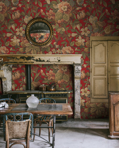 Tapet floral vintage cu flori bogate pe fundal roșu, decorând un interior cu o atmosferă clasică și elegantă